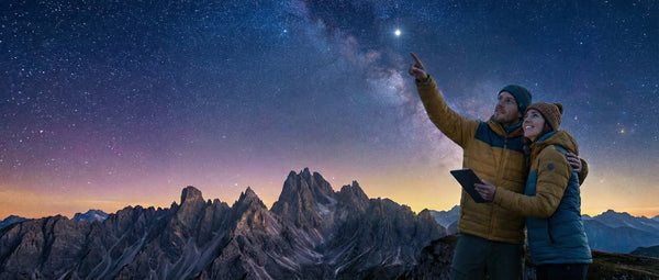 A couple pointing to a star in the night sky